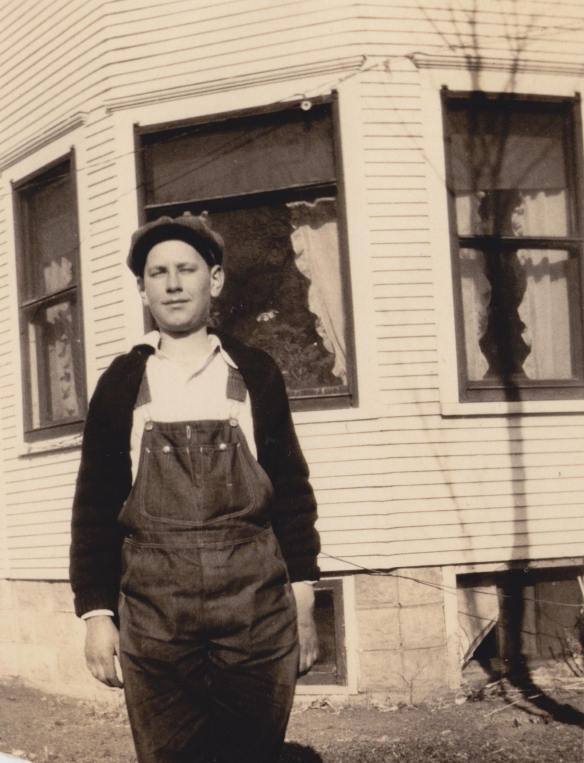Grandpa on his family farm in Nebraska sporting overalls and a no-iron hat.